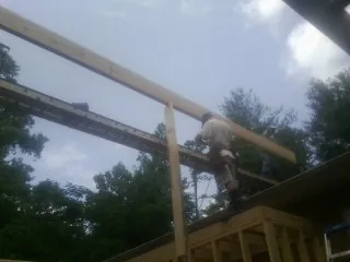 Carpenter setting a ridge beam over a new addition frame — Ice Dam Removal by Roofing Brothers in Upper Black Eddy