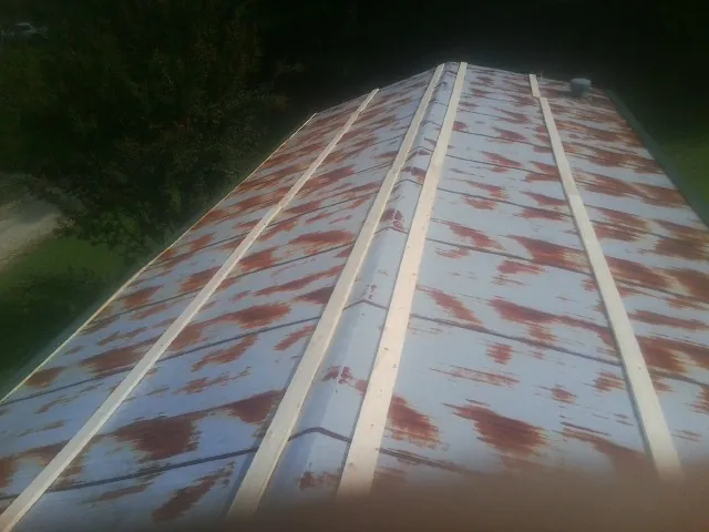 Rusted metal roof panels with new wood purlins before replacement — Storm Damage Roof Repair in Upper Black Eddy by Roofing Brothers