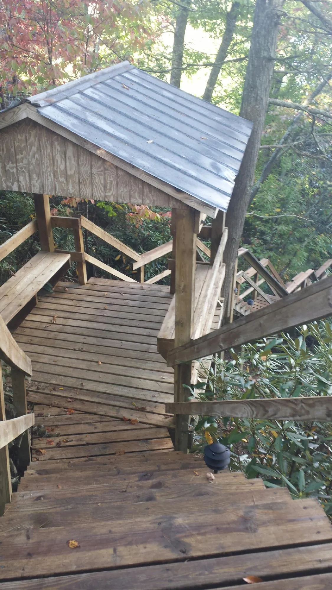 Metal roofed shelter over wooden steps on a wooded walkway — Skylight Repair & Installation work by our crew in Upper Black Eddy