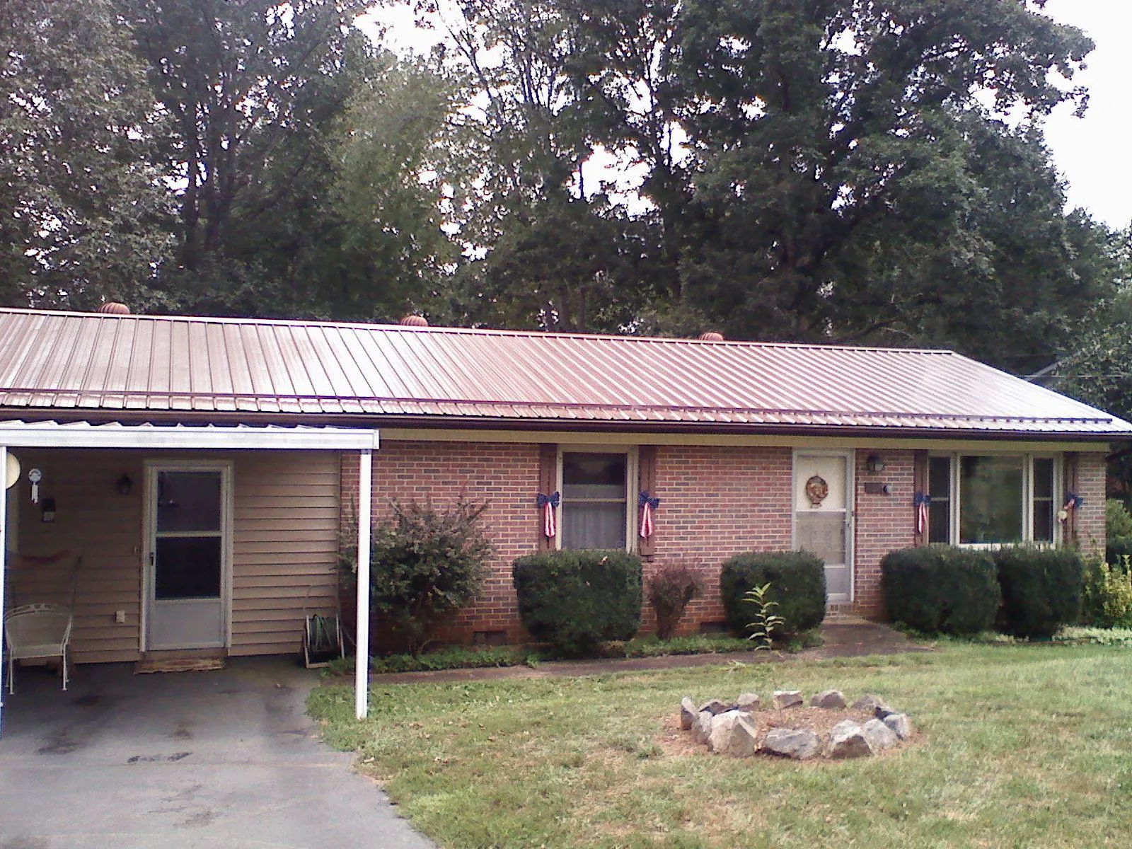 Bronze metal roof and carport on a brick ranch home — Roof Repair work by our crew in Upper Black Eddy