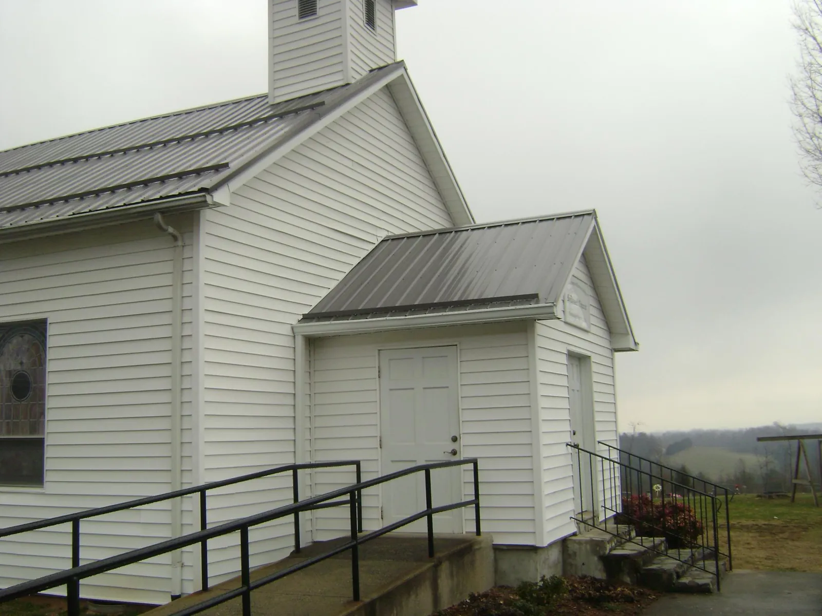 Gray metal roof on a white clapboard church with a steeple in Upper Black Eddy